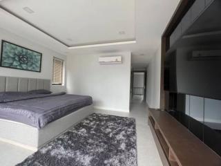 Modern bedroom with queen-sized bed and large flat-screen TV