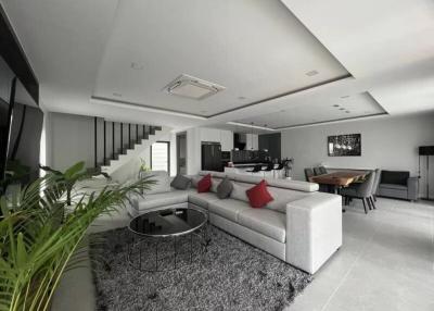 Spacious modern living room with open-plan design, comfortable seating, and dining area