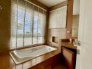 Spacious bathroom with large window and bathtub