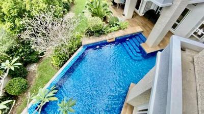 Aerial view of a backyard with a swimming pool, garden, and part of a residential building