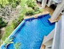 Aerial view of a backyard with a swimming pool, garden, and part of a residential building