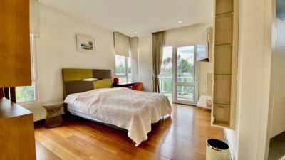Bright and modern bedroom with wooden flooring and balcony access
