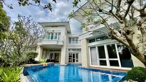 Spacious two-story house with a large swimming pool and lush garden