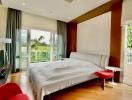 Spacious bedroom with a large bed, modern furniture, and balcony access