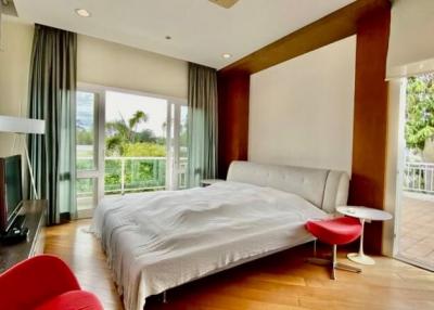Spacious bedroom with a large bed, modern furniture, and balcony access