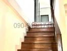 Wooden staircase leading to the upper floor with a black metal railing