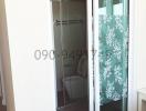 Modern bathroom with glass shower enclosure and floral pattern curtain