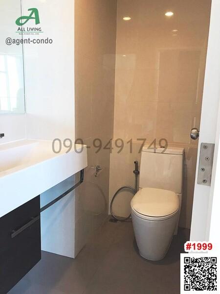 Modern bathroom with white and beige tiles featuring a sink, toilet, and shower