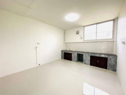 Bright, spacious modern kitchen with marble countertops and white cabinetry