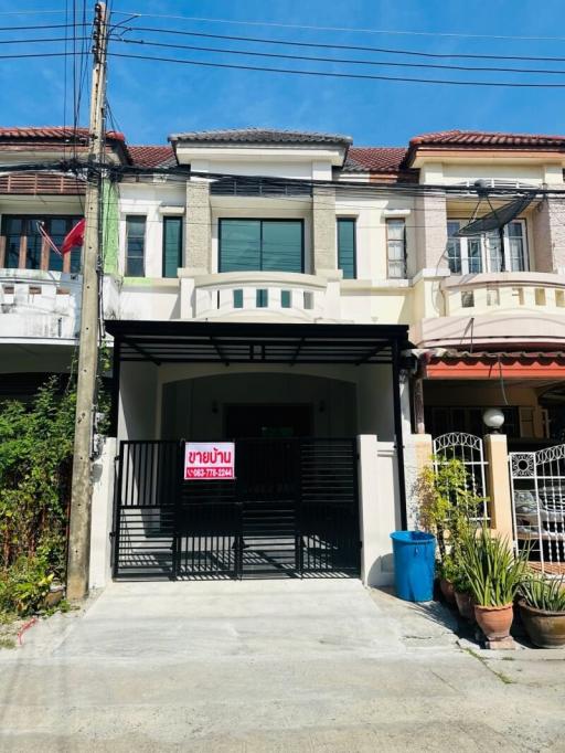 Exterior view of a modern duplex house with a gated parking area