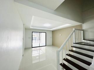 Bright and spacious living room with stairway and large window