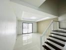 Bright and spacious living room with stairway and large window