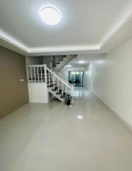 Bright and spacious hallway with staircase and tiled flooring