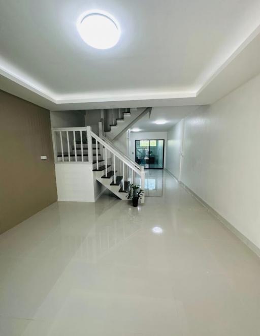 Bright and spacious hallway with staircase and tiled flooring