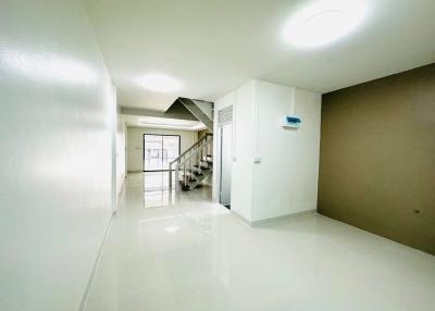 Bright and spacious hallway with staircase and tiled flooring