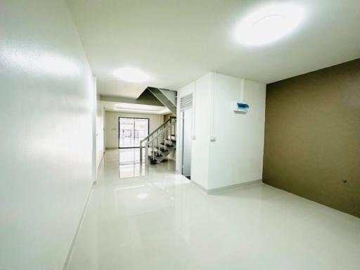 Bright and spacious hallway with staircase and tiled flooring