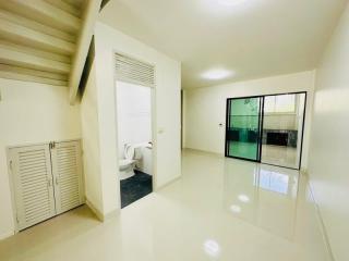 Bright and spacious bedroom with glossy tiled flooring and sliding door access to en-suite bathroom