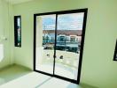 Bright bedroom with large windows and a view of neighboring houses