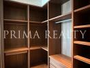 Spacious walk-in closet with built-in wooden shelves and drawers