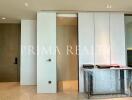 Modern entryway with elegant design and clean lines showcasing sliding doors and a wrapped furniture piece