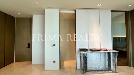 Modern entryway with elegant design and clean lines showcasing sliding doors and a wrapped furniture piece