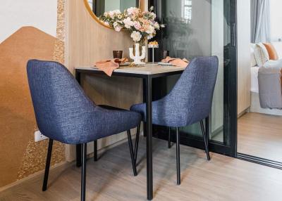 Modern dining space with seating for two, adjacent to the bedroom area