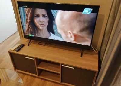 Modern television on a wooden tv stand in a living room