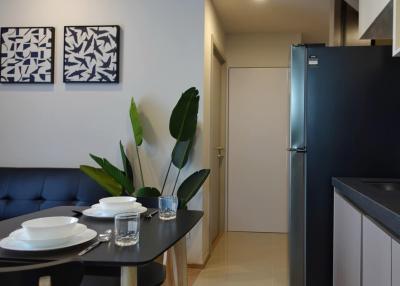 Modern kitchen with a dining area featuring a black refrigerator, a compact dining table, and decorative wall art