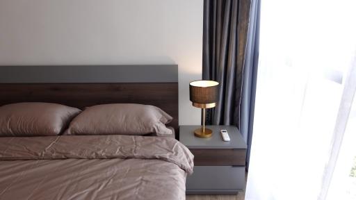 Cozy bedroom with comfortable bedding and modern lamp on bedside table