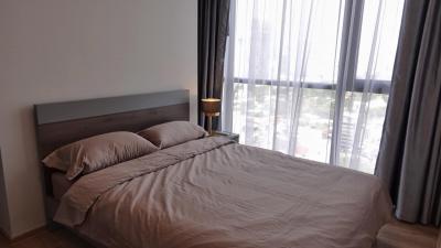 Modern bedroom with a large window and city view