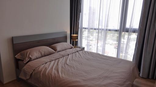 Modern bedroom with a large window and city view