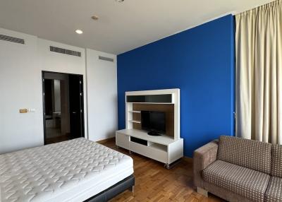 Spacious bedroom with a large bed and entertainment unit