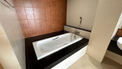 Contemporary bathroom with a white bathtub and wooden wall accent