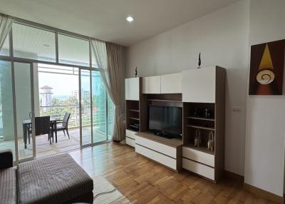 Spacious living room with natural light, balcony access, and modern furniture