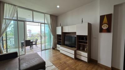 Spacious living room with natural light, balcony access, and modern furniture