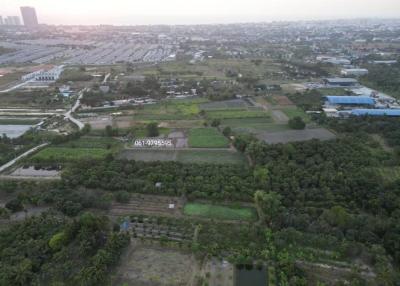 Aerial view of a potential development site with green fields and urban background