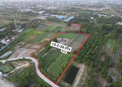 Aerial view of a large land plot available for sale surrounded by lush greenery