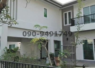 Modern two-story house with balconies and fenced yard