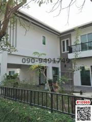 Modern two-story house with balconies and fenced yard