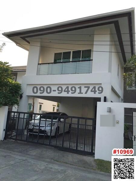 Modern two-story residential house with a gated entrance and a car parked