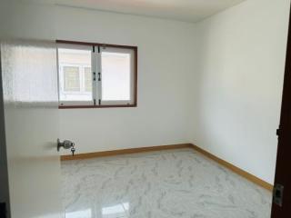 Bright and empty bedroom with tiled floor and a window