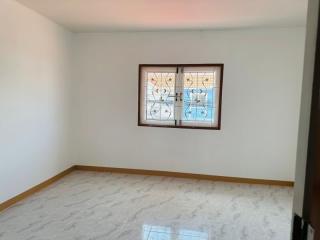 Empty bedroom with stained glass window and tiled floor