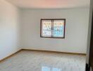 Empty bedroom with stained glass window and tiled floor