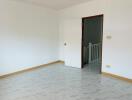 Empty room with open door and tiled flooring