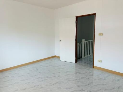 Empty room with open door and tiled flooring