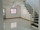 Spacious living room with staircase and marble flooring