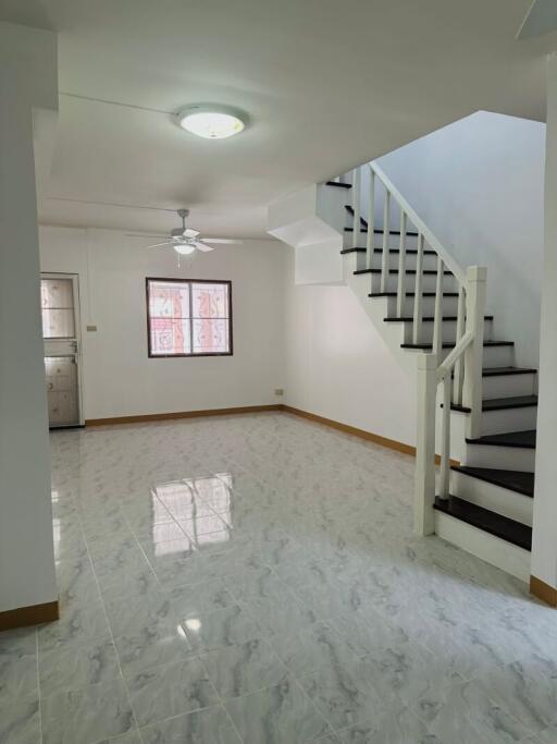 Spacious living room with staircase and marble flooring