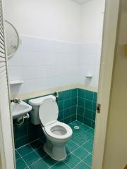 Compact tiled bathroom with toilet and sink