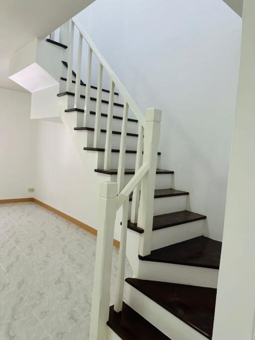 White staircase with wooden steps in a well-lit area