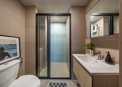 Modern bathroom with glass shower, toilet, and sink